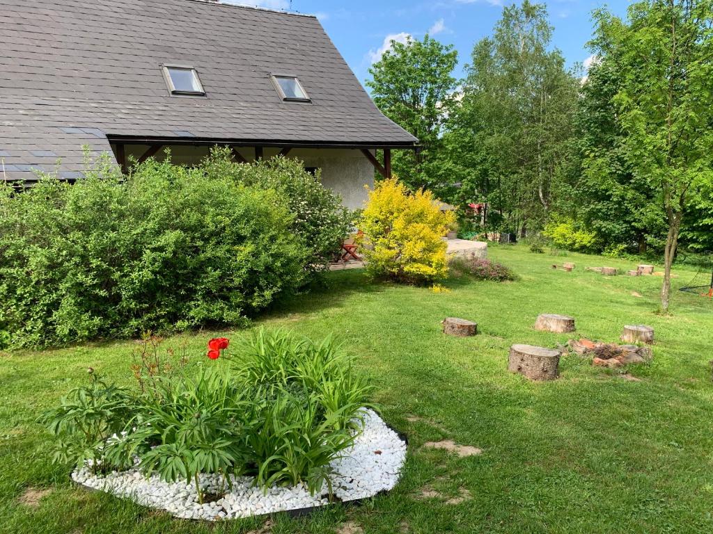 een tuin met een huis met een bloementuin bij Chalupa Krompach in Krompach