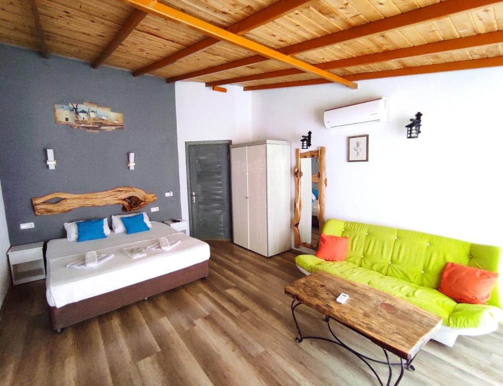 - un salon avec un canapé vert et un lit dans l'établissement Likya SUP Apart, à Kaş