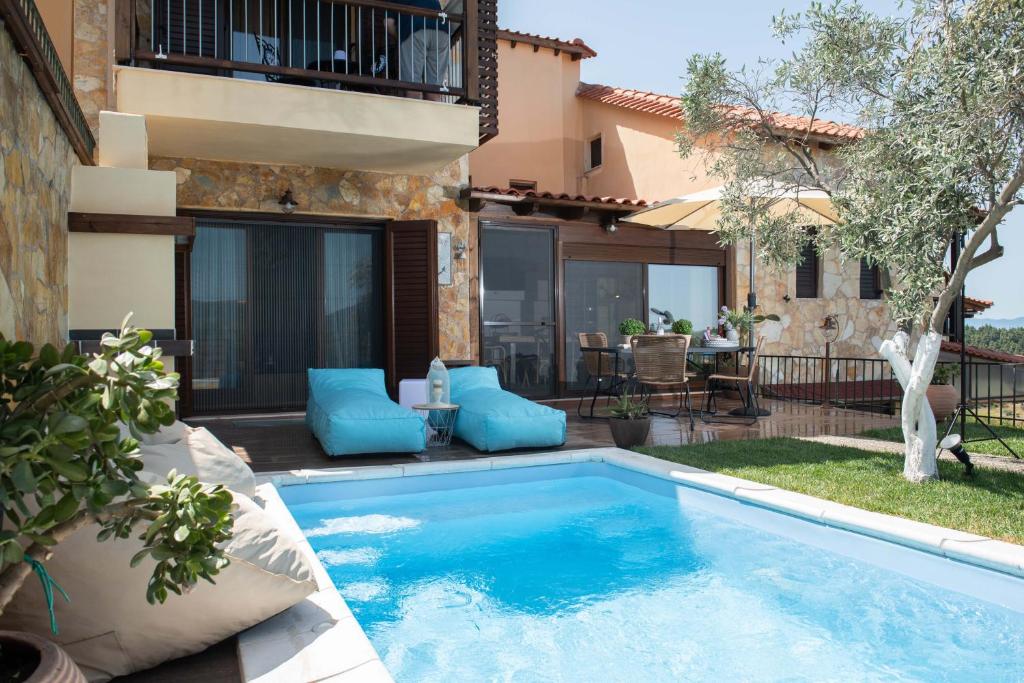 a swimming pool in the backyard of a house at Dandy Villas Nea Roda - Melodic Waves - Private - Pool - Parking - Cellar in Nea Roda