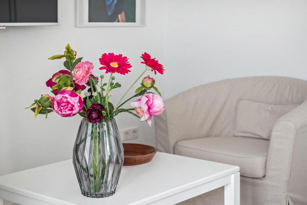 eine Vase von Blumen auf einem Tisch in der Unterkunft Ferienwohnung Rosenrot am See in Konstanz