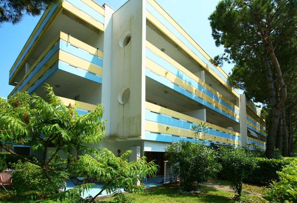 a large white building with trees in front of it at Halley in Bibione