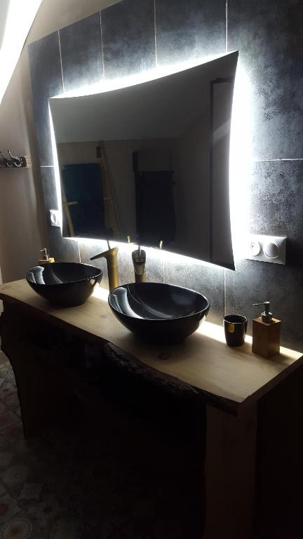a bathroom counter with two sinks and a mirror at Appartement spacieux et atypique in Sedan