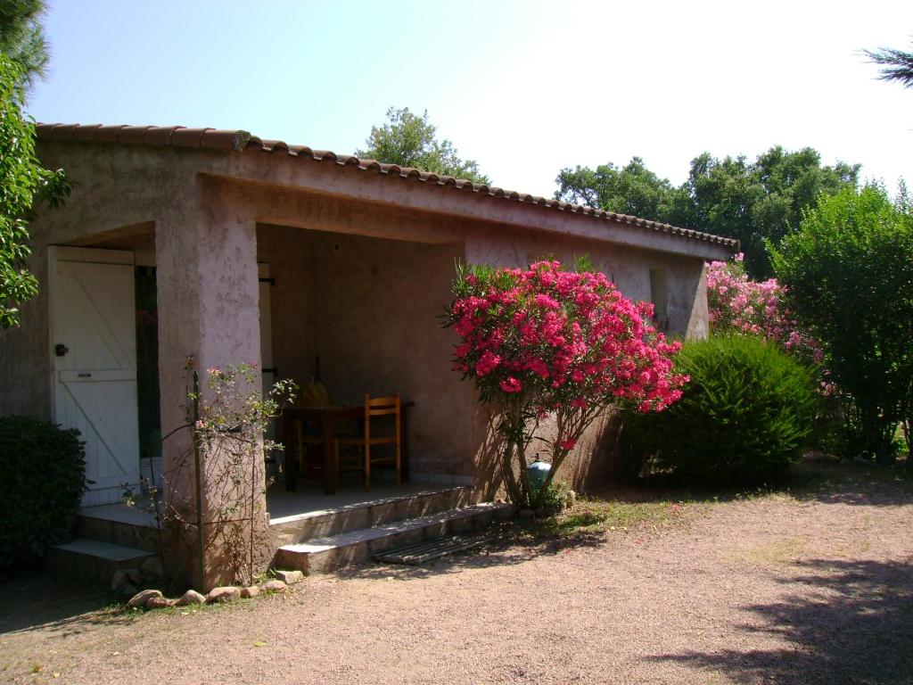 une petite maison avec une véranda ornée de fleurs roses dans l'établissement Le Pin Parasol, à Porto-Vecchio
