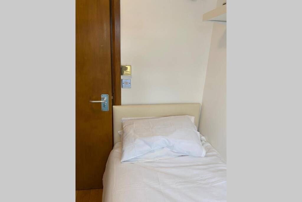 a bed with a white pillow in a room at F405-Comfy Studio for 1 near Hyde Park in London