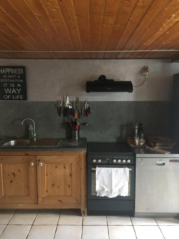La cocina está equipada con fogones, fregadero y encimera. en MAISON MEDOC, en Gaillan-en-Médoc