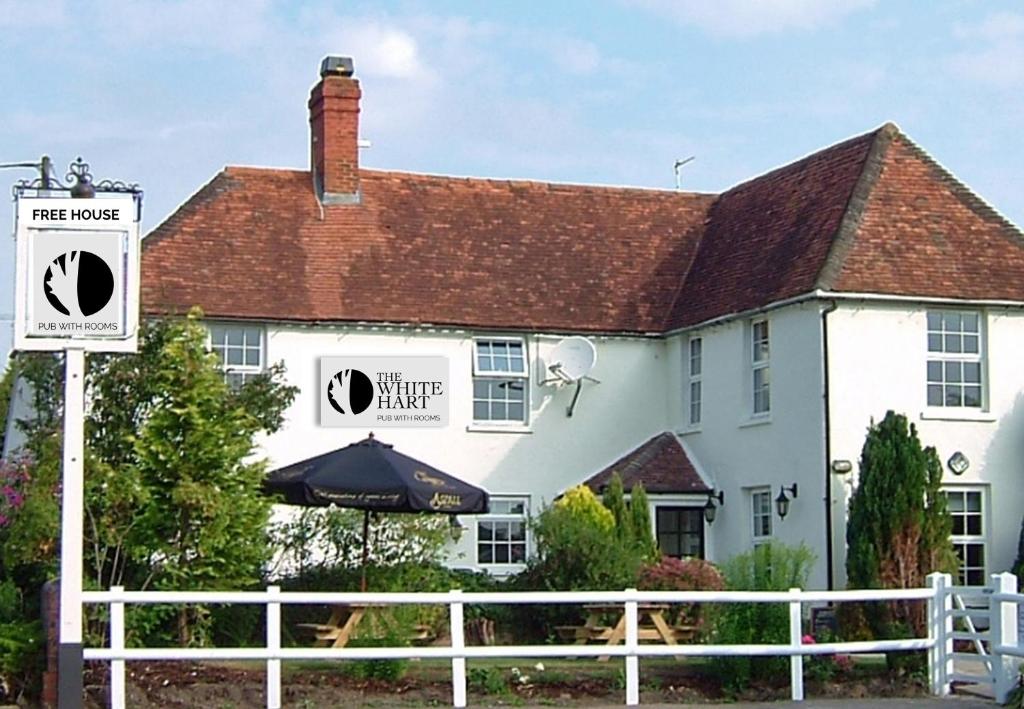 a white house with a white fence next to a white house at The White Hart Inn in Newbury