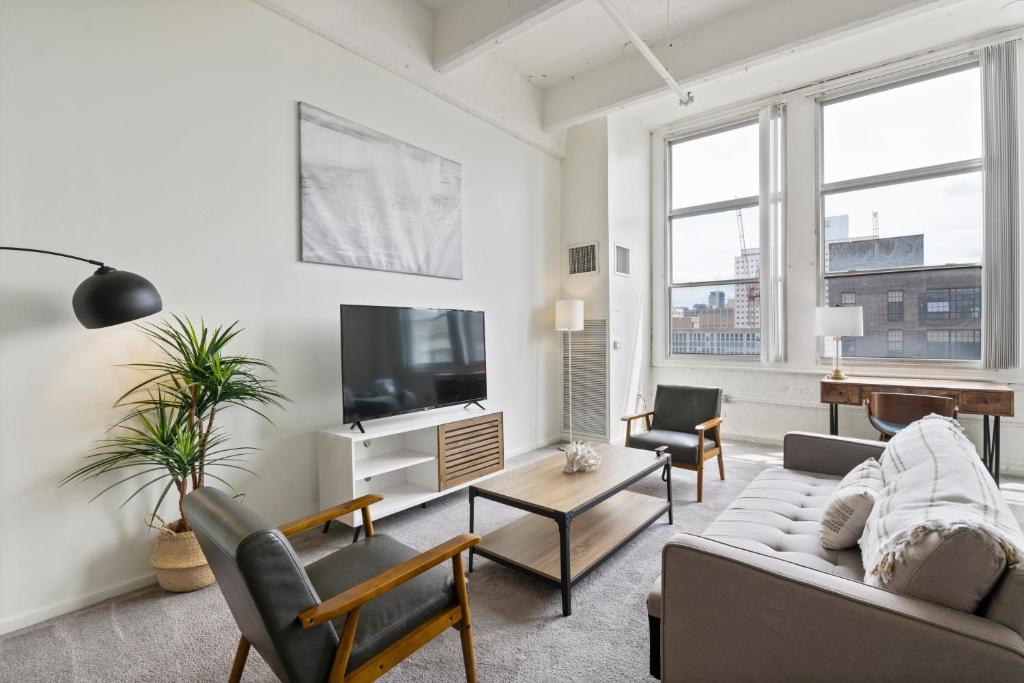a living room with a couch and a tv at Loft640 in Center City w Parking, Pool, Gym in Philadelphia