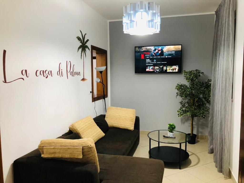 sala de estar con 2 sofás y TV en La casa di Palma, en Catania
