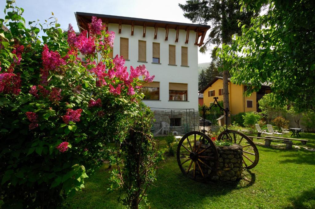 a house with a garden with flowers and a wagon at Villa Myosotis in Bardonecchia