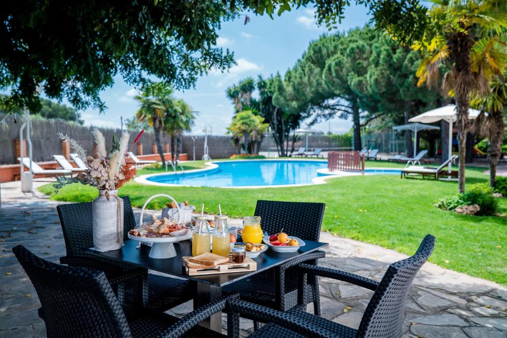 un tavolo con cibo sopra accanto a una piscina di Felix Hotel a Valls