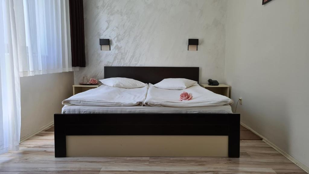a bedroom with a bed with white sheets and pillows at Hotel Royal Drina in Mali Zvornik