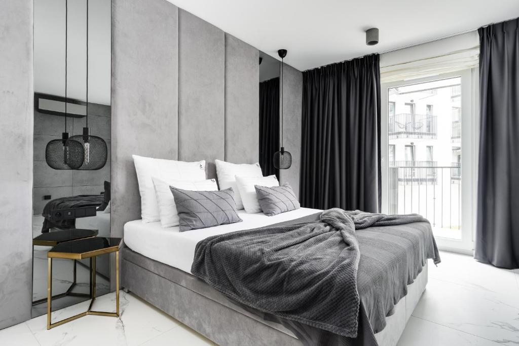 um quarto com uma cama grande e uma secretária em EL Apartments - Aries em Poznań