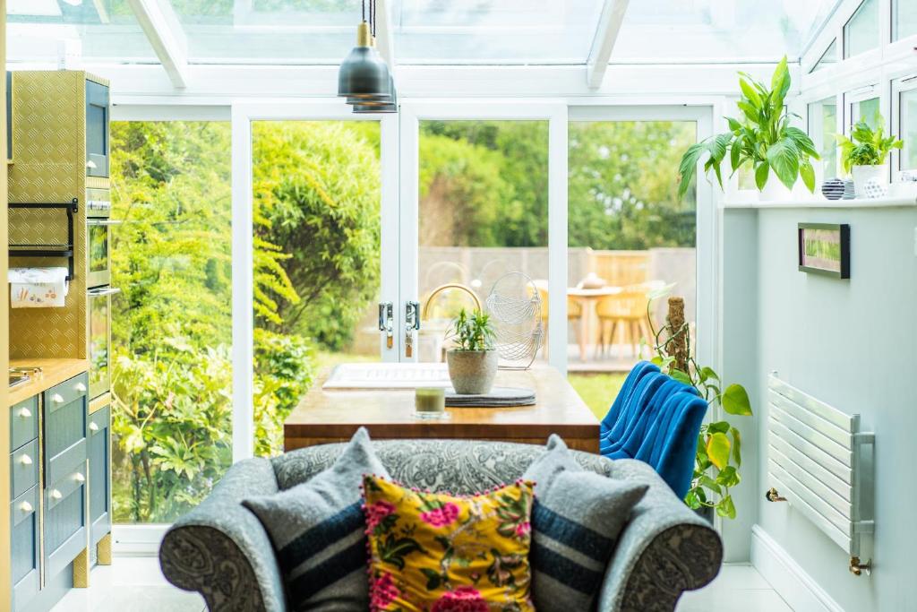 a conservatory with a couch and a table in a kitchen at You're Epic in Wimborne Minster