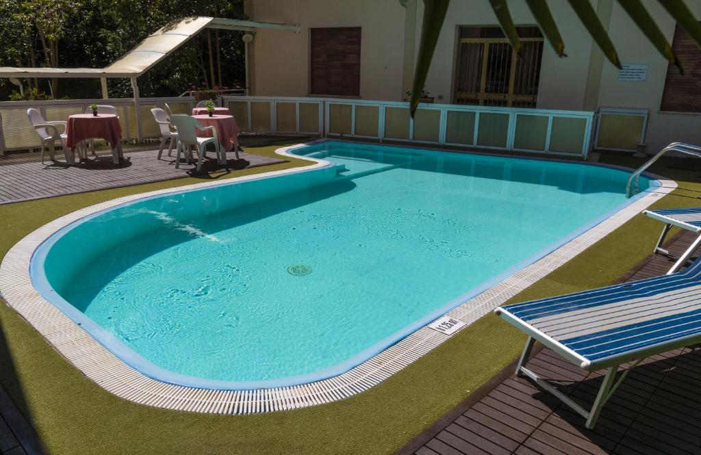 een groot zwembad met stoelen en een tafel bij Hotel Sanremo in Chianciano Terme