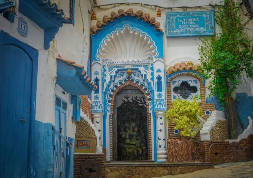 a blue and white building with a clock on it at Dar Touijar in Chefchaouen