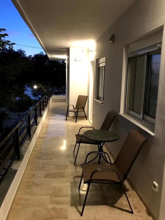 uma varanda com cadeiras e uma mesa num edifício em Tasoula's Beachside Rooms em Palaiochora