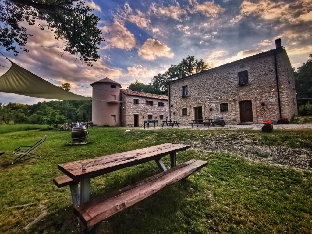 una panchina di legno seduta sull'erba di fronte a un edificio di Dimora Barbolani a Lettopalena