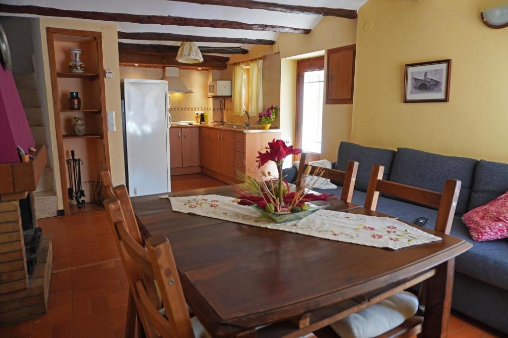 a kitchen and dining room with a wooden table and chairs at Casa El Cuatro in Beceite