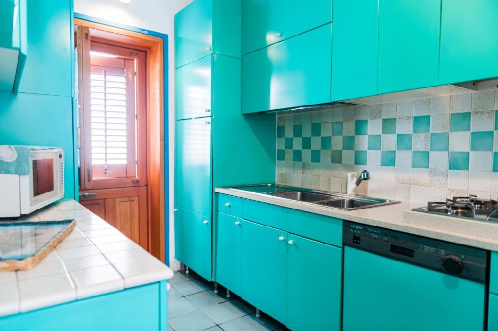 una cucina verde con armadi blu e lavandino di Acquamarina guest house a Marettimo