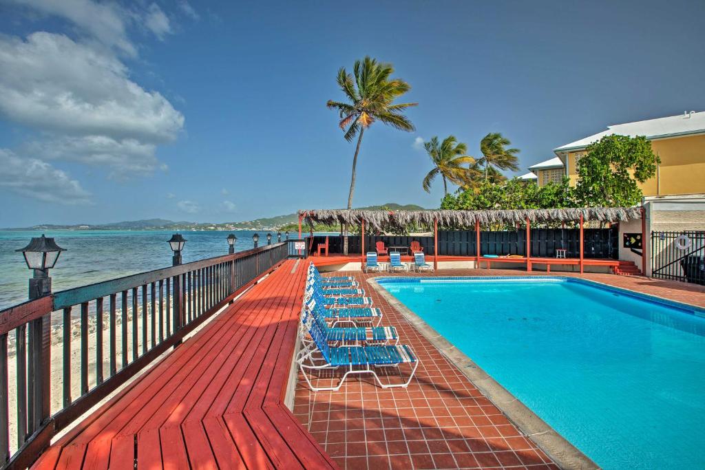 Beachfront St Croix Condo with Pool and Lanai! في كريستيانستيد: مسبح وكراسي الصالة بجانب المحيط