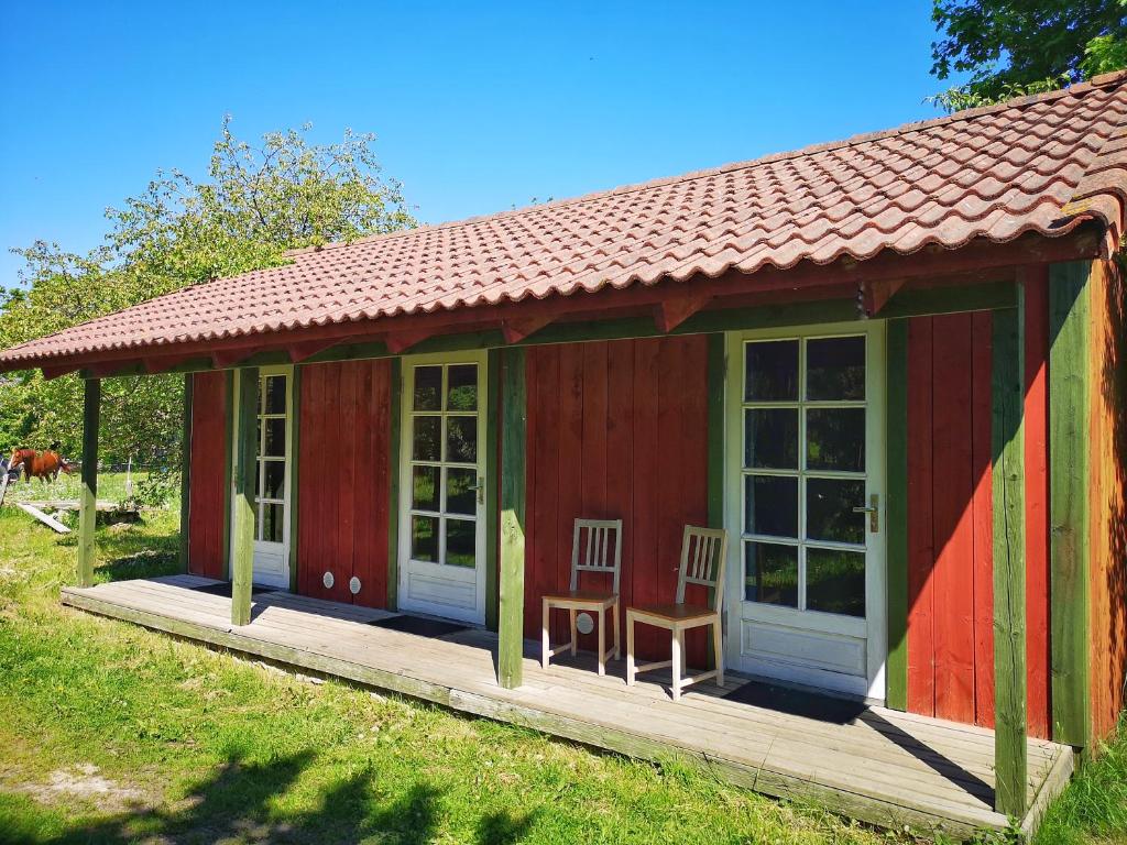 um barracão vermelho e verde com uma mesa e cadeiras em Tika Farmstay em Kõrkvere