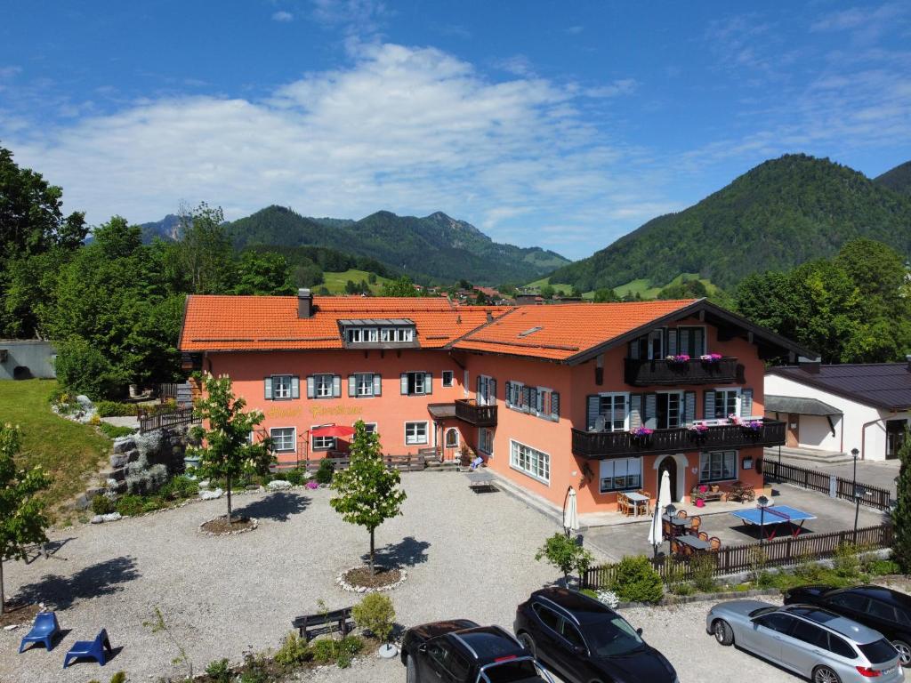 a large building with cars parked in a parking lot at Hotel Garni Forsthaus Ruhpolding in Ruhpolding