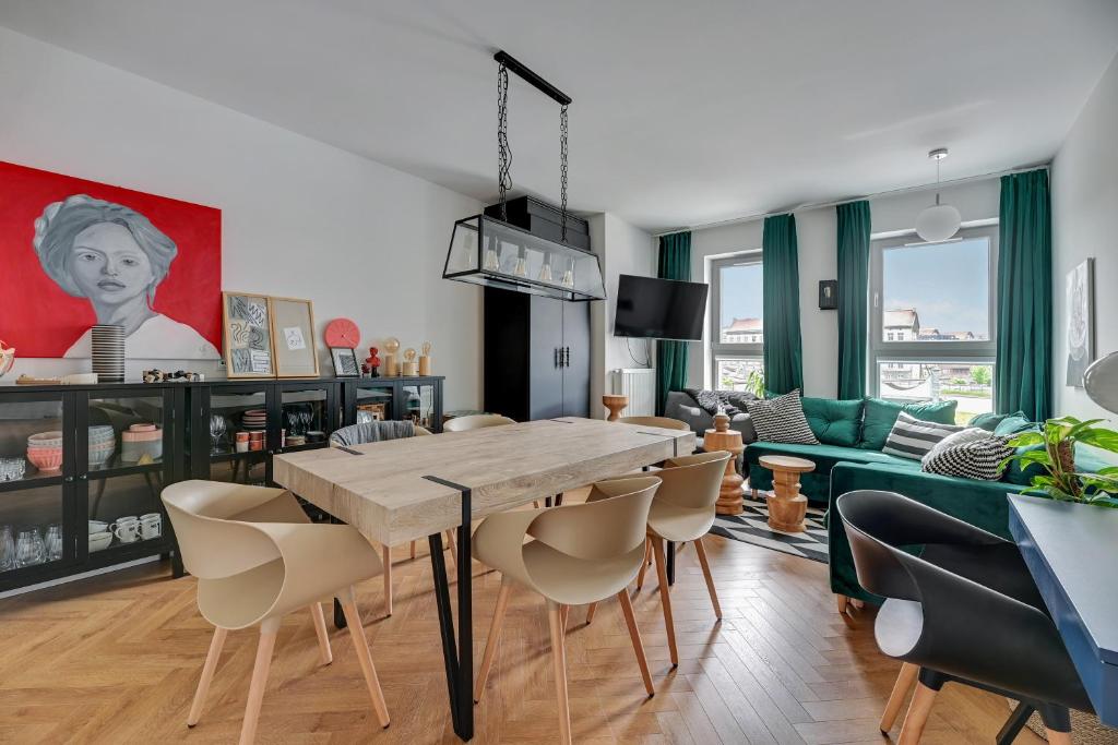 a living room with a wooden table and chairs at Queen's Gambit by Blue Mandarin in Gdańsk