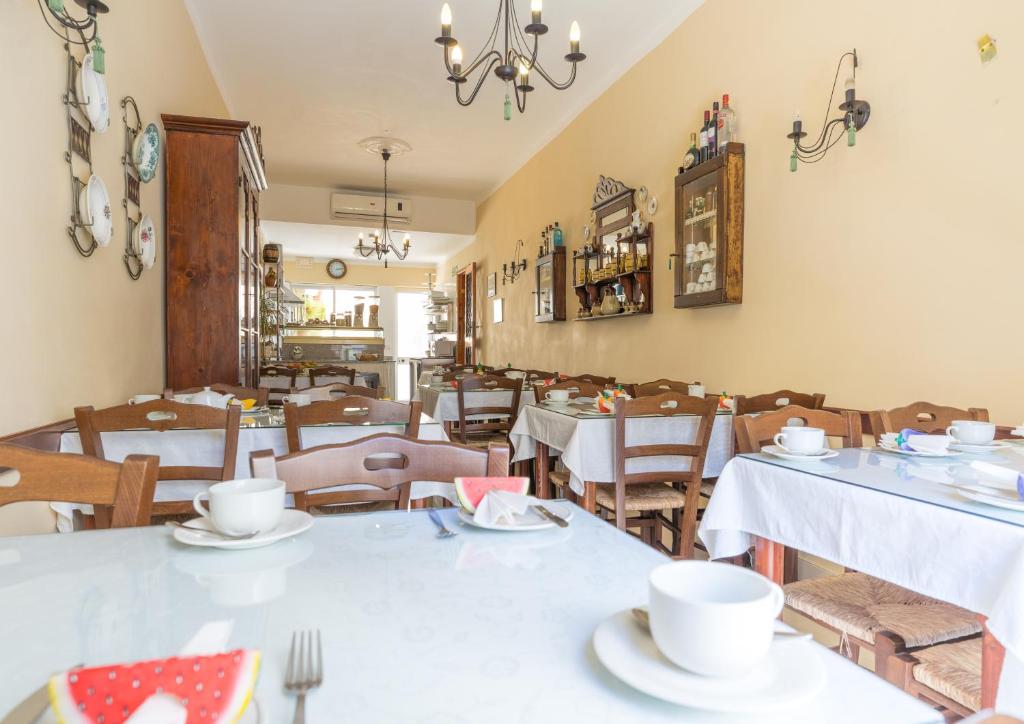 a dining room with white tables and chairs at Lantern Guest House in Marsalforn