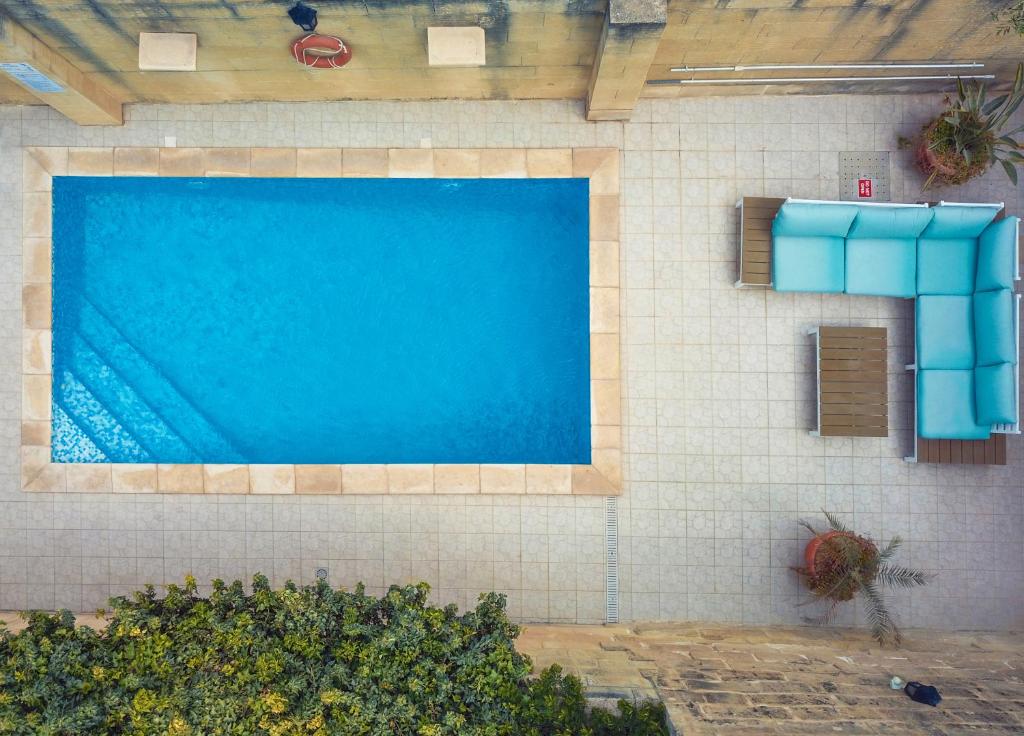 een gebouw met een blauw zwembad erop bij Superb Maltese Farmhouse with Private Pool in Victoria