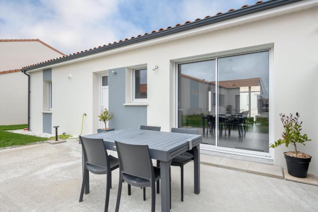 a dining table and chairs in front of a house at Maison moderne pour 7 personnes à Saint-Michel-Chef-Chef in Saint-Michel-Chef-Chef