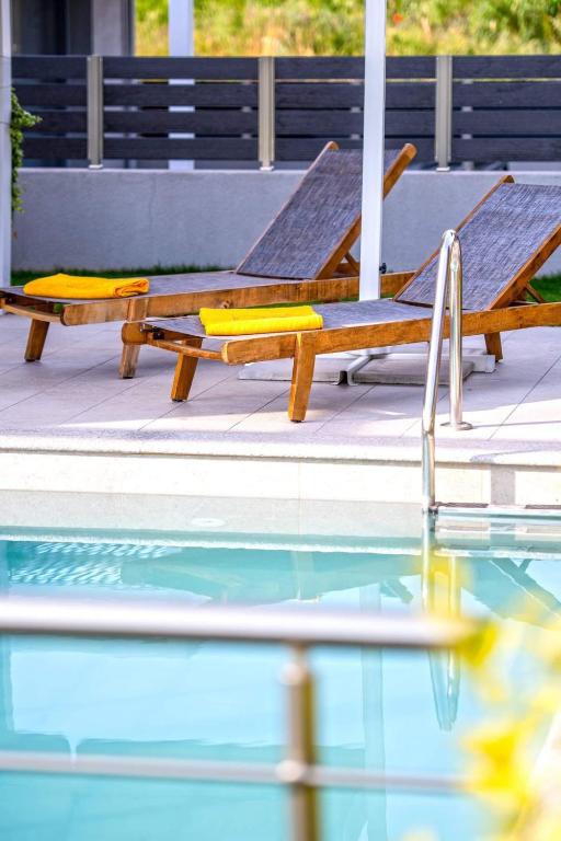 two lounge chairs sitting next to a swimming pool at AG Luxury Villas, Iraklitsa in Iraklitsa