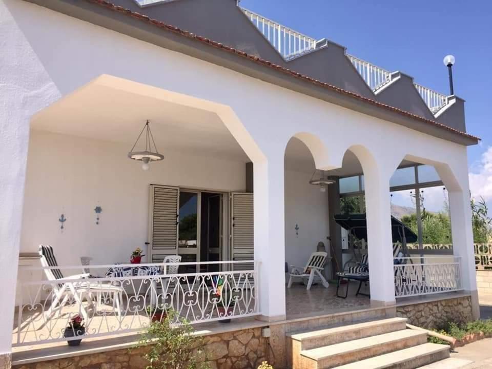 una casa bianca con patio arredato con sedie e tavoli di Villa Giulia ad Alcamo Marina