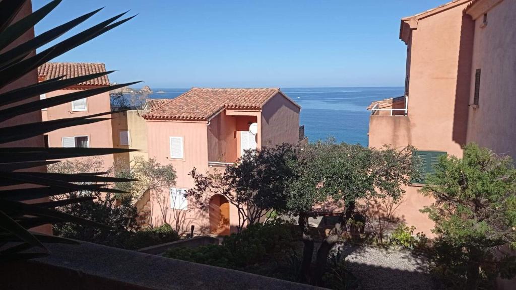 a view of two buildings with the ocean in the background at residence Mare Turchinu in Monticello