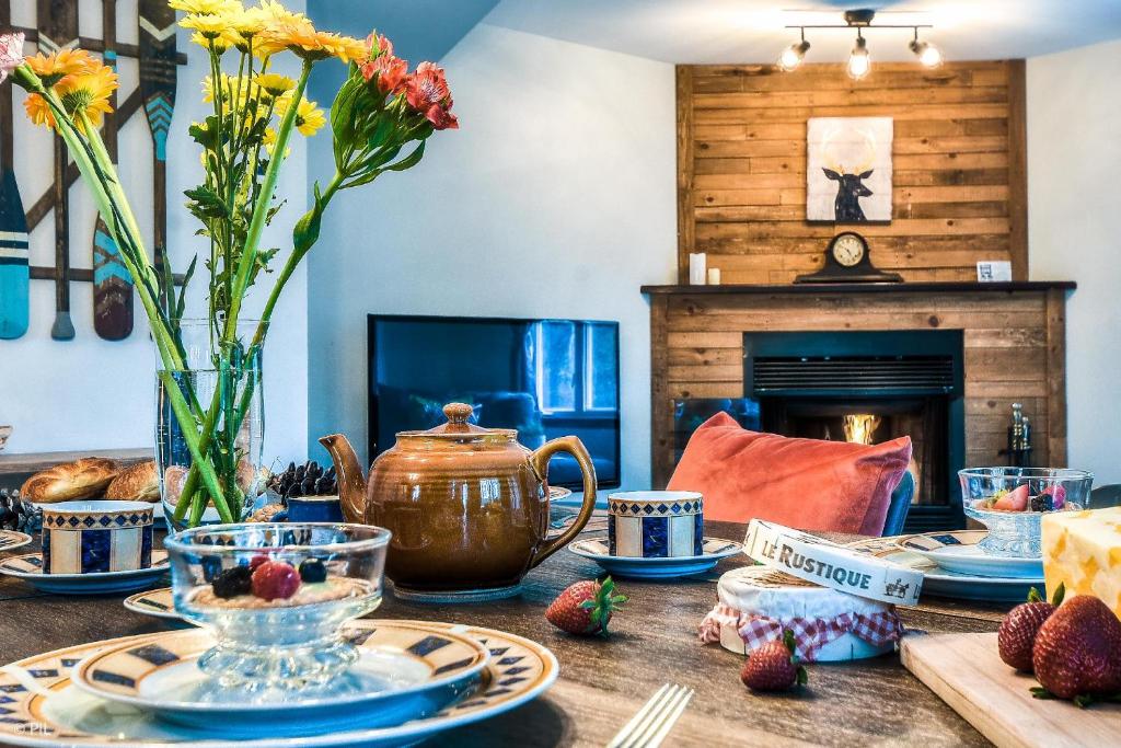 a table with dishes and a tea pot on it at Townhouse On The Golf W Pool Access -aiglon 1717 in Mont-Tremblant