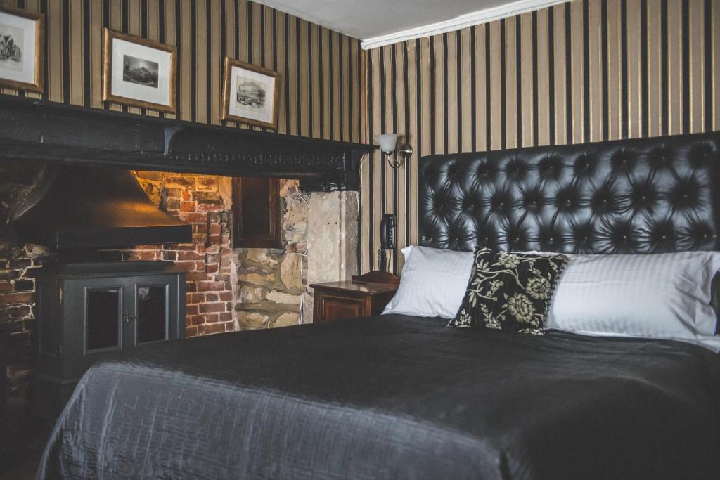 a bedroom with a large bed and a fireplace at Jeakes House in Rye
