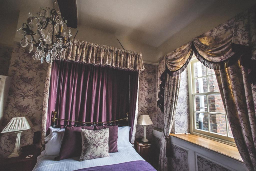 a bedroom with a canopy bed and a window at Jeakes House in Rye
