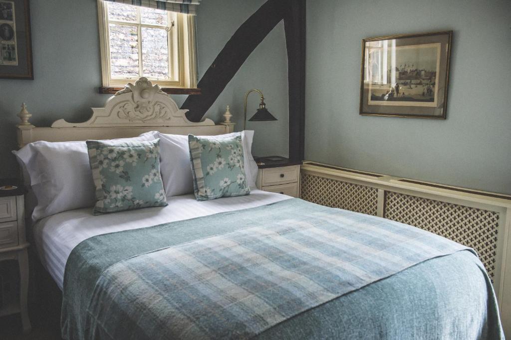 a bedroom with a large bed with a blue blanket at Jeakes House in Rye