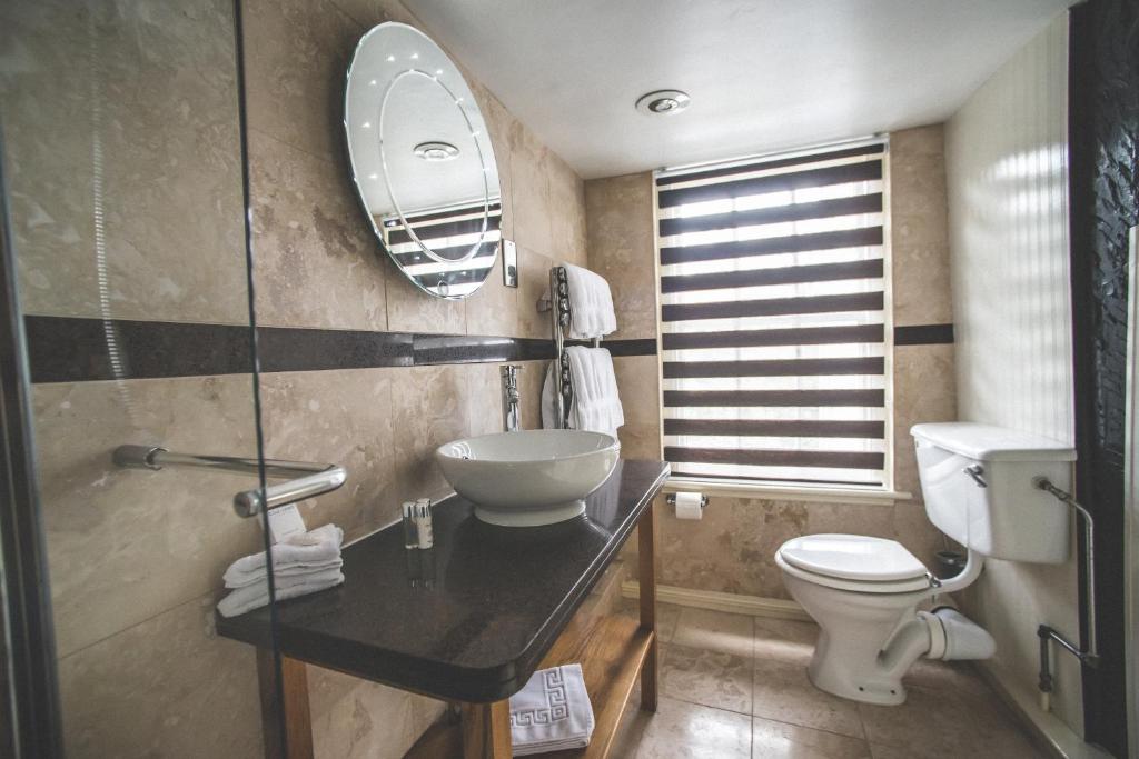 a bathroom with a sink and a toilet and a mirror at Jeakes House in Rye