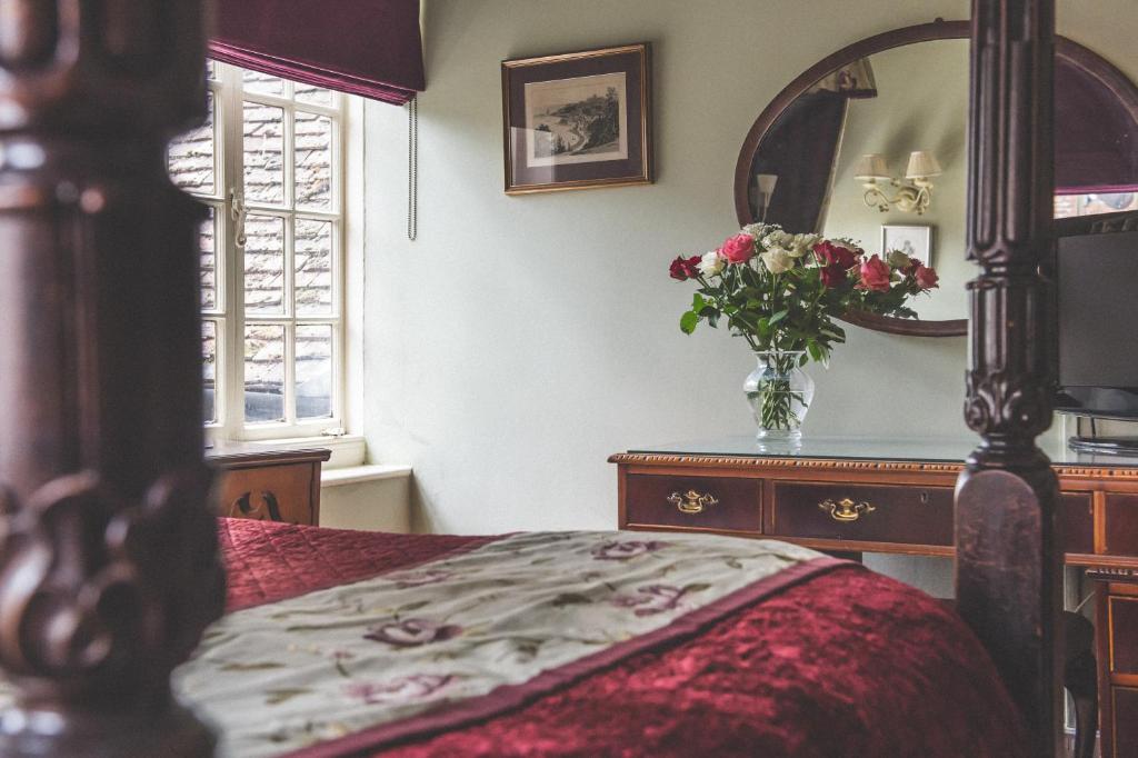 a bedroom with a bed and a vase of flowers at Jeakes House in Rye