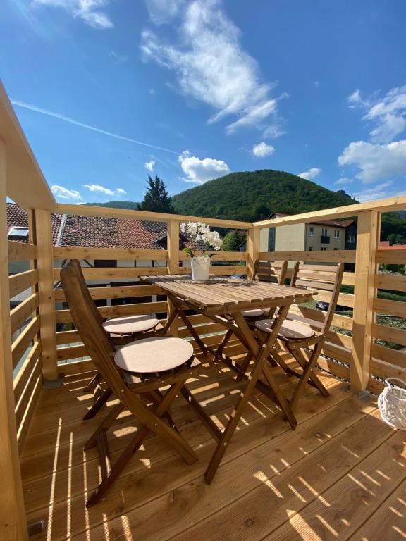 einen Holztisch und Stühle auf einer Holzterrasse in der Unterkunft Ferienwohnung Bergblick in Thale