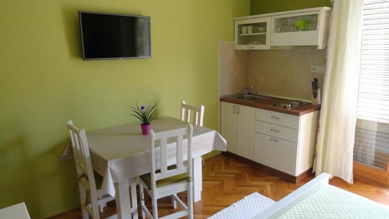 a dining room with a table and a kitchen at Studio Apartment in Palit with Balcony, Air Conditioning, Wi-Fi (4603-4) in Mundanije