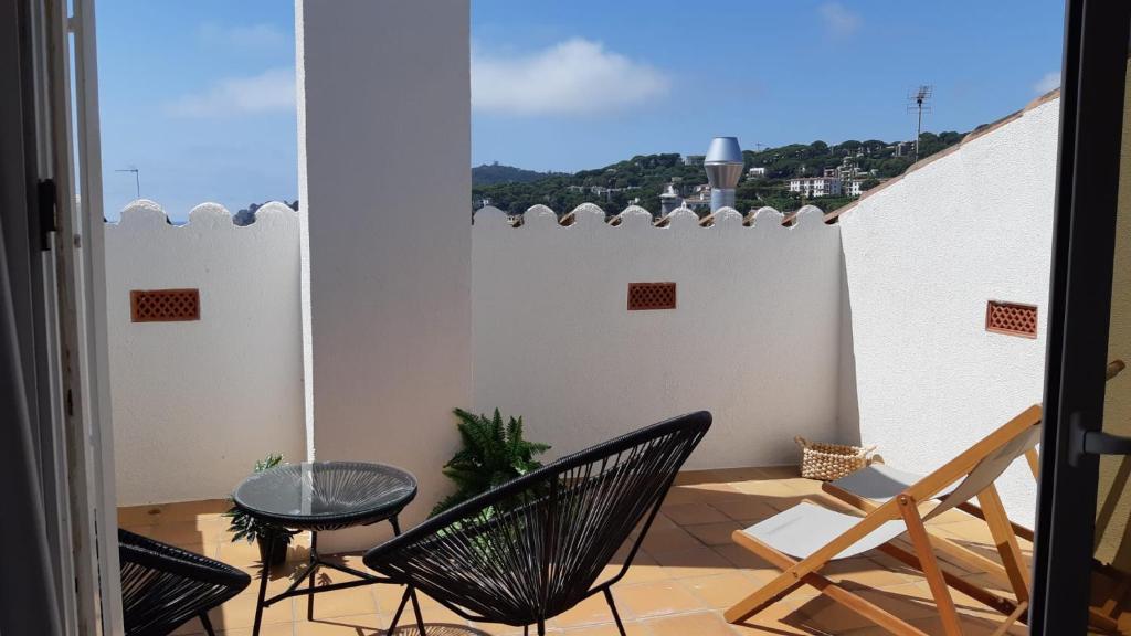 a balcony with chairs and a table and a window at BLAU Bonito Duplex con Terraza in Calella de Palafrugell