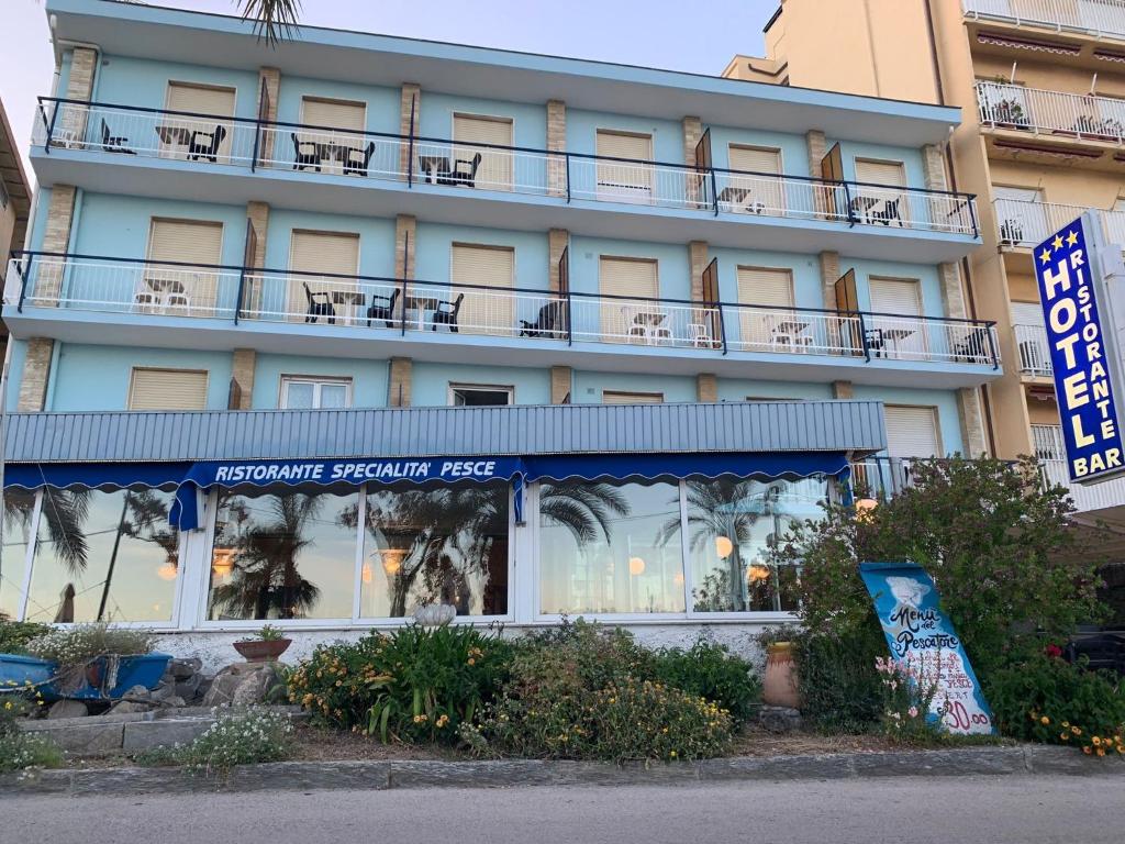 a hotel with a blue building with a balcony at Hotel Svizzera in Arma di Taggia