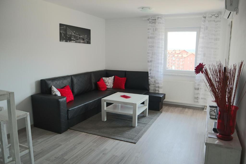 a living room with a black couch and a table at Apartman Lilly in Modriča