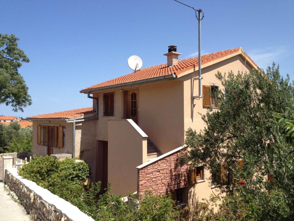 een huis met een satelliet op het dak bij Apartments Ivanković in Preko