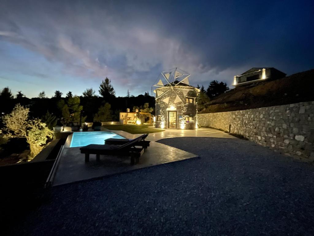 a house with a swimming pool at night at Windmills Village Amarynthos in Amarinthos