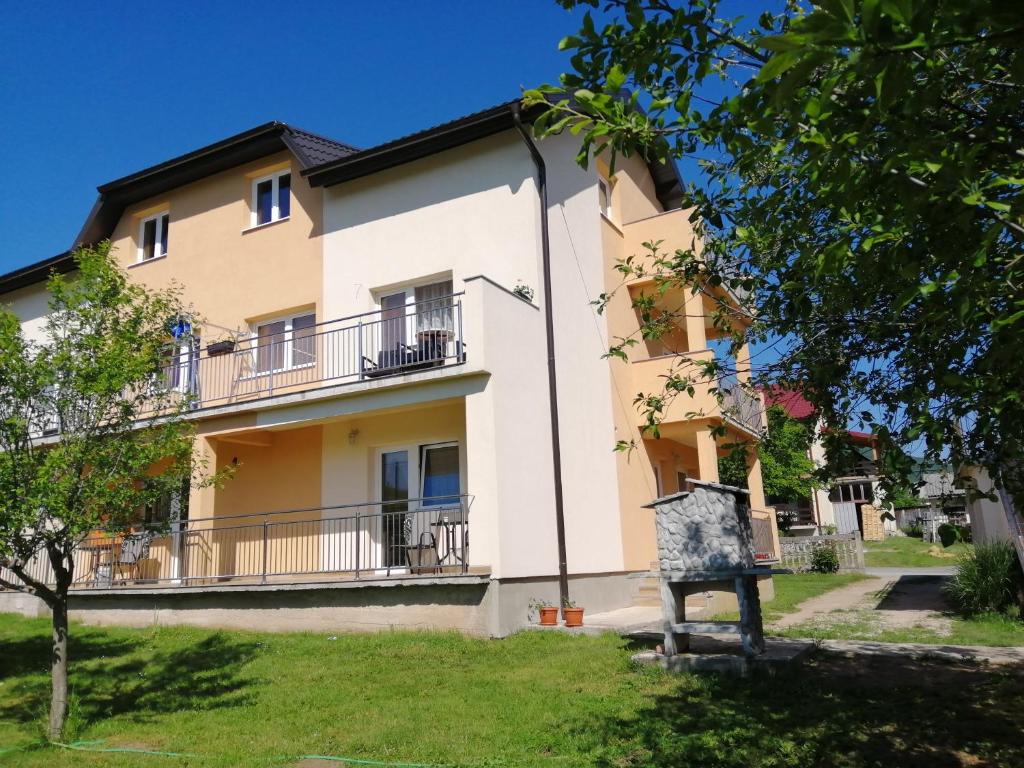 a large building with balconies in a yard at Rooms Ana in Korenica