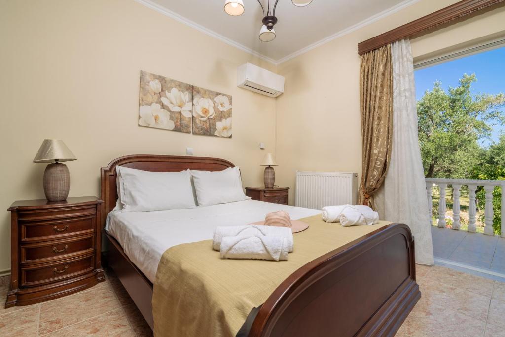 um quarto com uma cama grande e uma janela em Olive de Villa em Áyios Dhimítrios