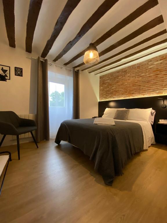 a bedroom with a bed and a brick wall at Apartamento Logroño Parlamento in Logroño
