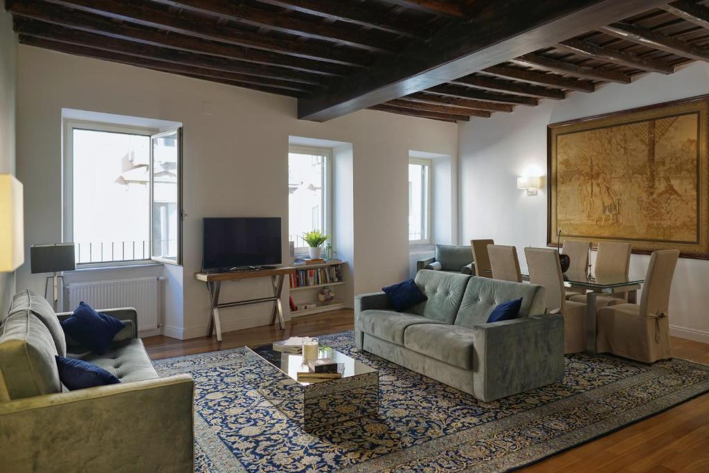 a living room with two couches and a tv at Barberini Apartment in Rome